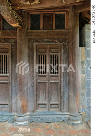 Traditional wooden architecture with ornate doors and carved pillars at a historic pagoda in Vietnam Traditional wooden architecture with ornate doors and carved pillars at a historic pagoda in Vietnam 143072540