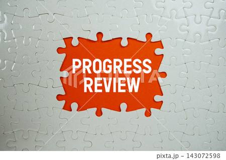 Jigsaw puzzle with a missing piece with "Progress Review" on orange background 143072598