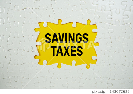 Jigsaw puzzle with a missing piece with "Savings Taxes" on yellow background 143072623