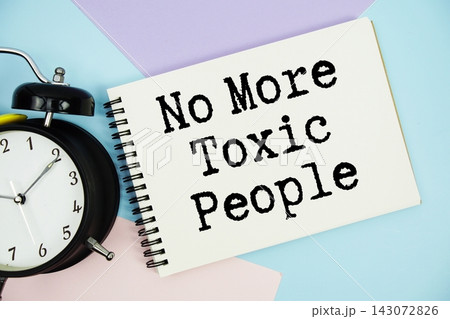No More Toxic People text written on notepad with alarm clock flat lay on multicolor pastel background 143072826