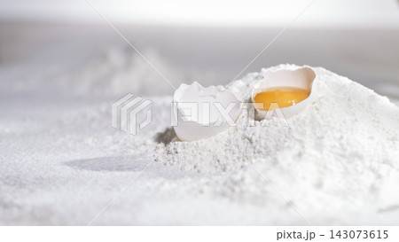 Eggshell and yolk resting on flour pile Eggshell and yolk resting on flour pile 143073615
