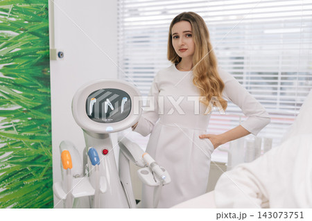 Portrait of professional cosmetologist standing in modern beauty clinic, showcasing advanced SMAS lifting technology for skin rejuvenation and anti-aging treatments, offering expert aesthetic services Portrait of professional cosmetologist standing in modern beauty clinic, showcasing advanced SMAS lifting technology for skin rejuvenation and anti-aging treatments, offering expert aesthetic services 143073751