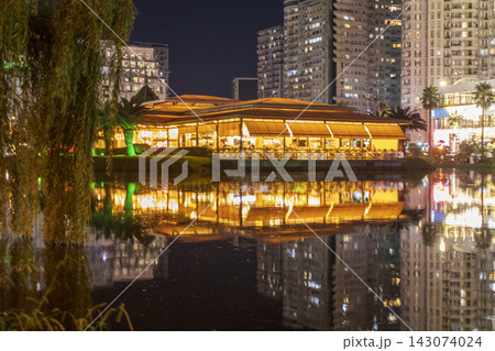 Batumi, Georgia - September 2, 2026: Night view of an illuminated waterfront restaurant on Ardagani Lake reflecting in the water against a background of city high-rises. Travel Batumi, Georgia - September 2, 2026: Night view of an illuminated waterfront restaurant on Ardagani Lake reflecting in the water against a background of city high-rises. Travel 143074024