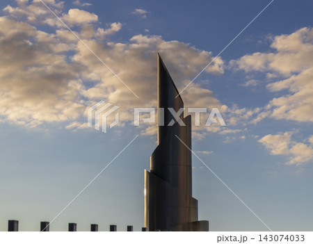 Low angle architectural detail of a modern twisting skyscraper facade made of perforated steel panels. Outdoors Low angle architectural detail of a modern twisting skyscraper facade made of perforated steel panels. Outdoors 143074033