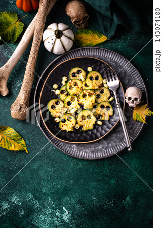 Halloween food. Marinated cucumber in shape of skull Halloween food. Marinated cucumber in shape of skull 143074180