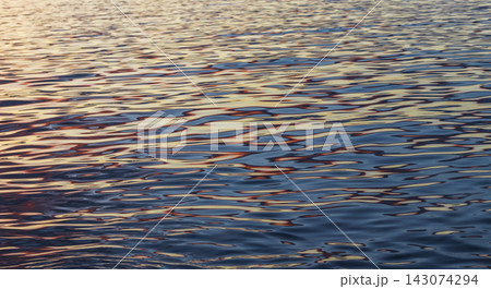 Abstract background texture of calm sea water ripples reflecting golden sunset colors. Concept Abstract background texture of calm sea water ripples reflecting golden sunset colors. Concept 143074294