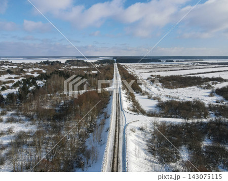 Aerial winter road through Belarus peatland, wetlands, and forests Aerial winter road through Belarus peatland, wetlands, and forests 143075115