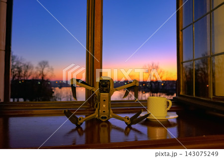 Drone on windowsill with coffee, sunset over Belarus river view 143075249