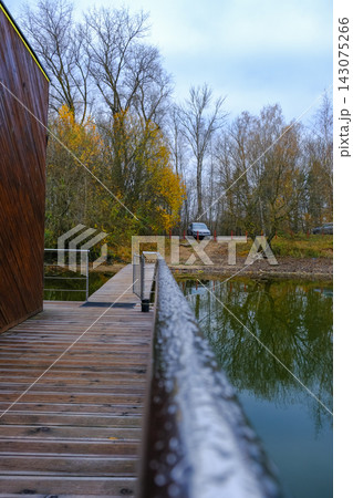 Wooden lakeside walkway and autumn forest reflection in Belarus Wooden lakeside walkway and autumn forest reflection in Belarus 143075266