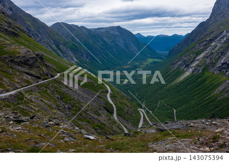 Aerial view of mountain valley with switchback road and river, Norway Aerial view of mountain valley with switchback road and river, Norway 143075394