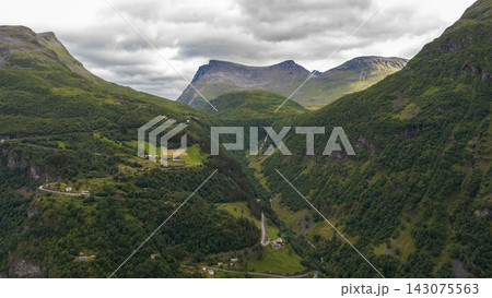 Aerial view of Homlung valley with forested slopes, mountain pass, and scattered settlements, Norway Aerial view of Homlung valley with forested slopes, mountain pass, and scattered settlements, Norway 143075563