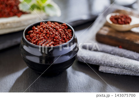 annatto grains in a container on a gray slate annatto grains in a container on a gray slate 143075700