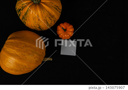 Festive pumpkins on a black surface for autumn celebration Festive pumpkins on a black surface for autumn celebration 143075907
