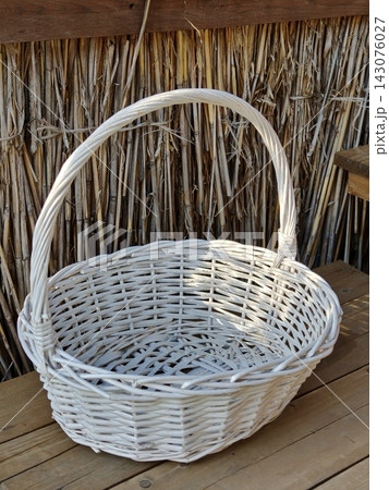 White woven wicker basket on a wooden table 143076027