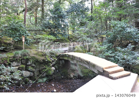 苔むす木立に架かる兼六園の千歳橋 143076049