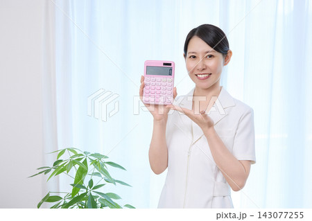 計算機を使って金額を示す女性 143077255