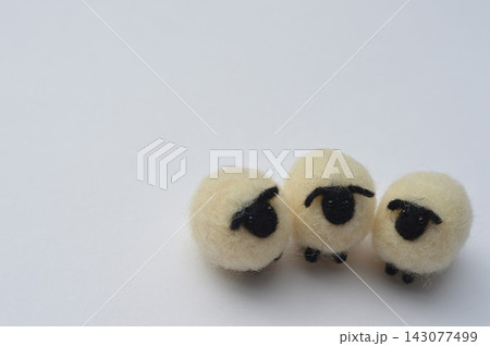 羊毛フェルトの黒い顔のひつじが並ぶ 143077499