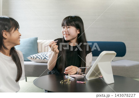 一緒にメイクをする姉妹 一緒にメイクをする姉妹 143078227