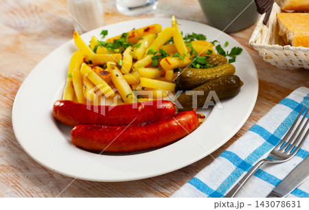 Sausages with potatoes and pickled cucumbers Sausages with potatoes and pickled cucumbers 143078631