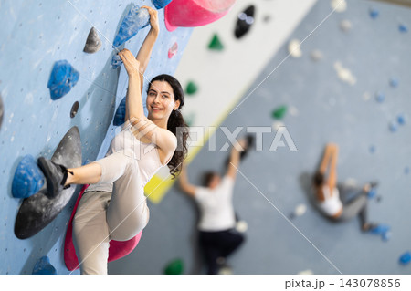 Young woman doing rock climbing on climbing wall Young woman doing rock climbing on climbing wall 143078856