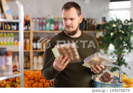 Man choosing mushrooms in the store 143078874