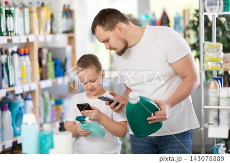 Dad and son scan barcode on packaging of laundry conditioner 143078889