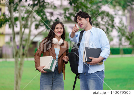 Asian university students holding books on campus for higher education Asian university students holding books on campus for higher education 143079506