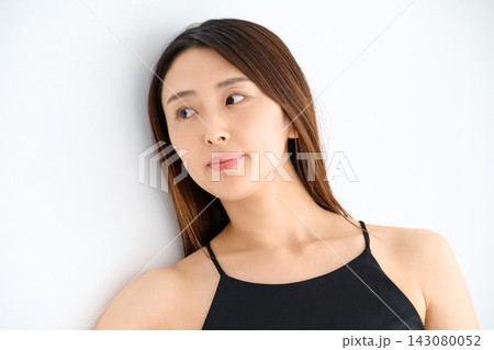 壁にもたれて横を見る黒いキャミソールの女性 143080052