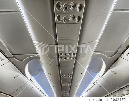 Airplane overhead cabin lockers and air vents interior ceiling view during flight. Airplane overhead cabin lockers and air vents interior ceiling view during flight. 143082375