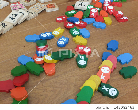 木の床に散らばったカラフルなアルファベットのドミノ 木の床に散らばったカラフルなアルファベットのドミノ 143082463