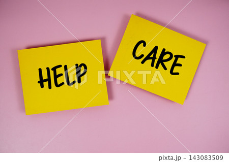Help and Care text written on paper notes top view on pink background Help and Care text written on paper notes top view on pink background 143083509