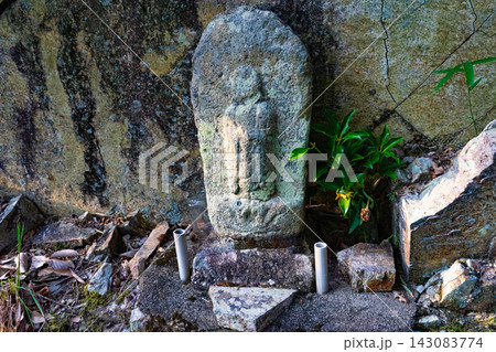 岩壁のそばに佇む風化した石仏 岩壁のそばに佇む風化した石仏 143083774