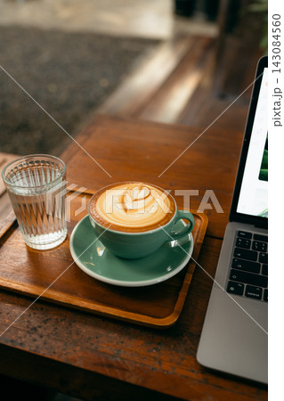 Remote work lifestyle, laptop screen showing photos with a cup of hot coffee on rustic wooden table. Remote work lifestyle, laptop screen showing photos with a cup of hot coffee on rustic wooden table. 143084560