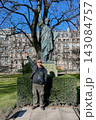 Man posing in front of a Statue of Liberty replica in Paris, France, on a sunny day. Travel, tourism and sightseeing concept. High quality photo 143084757