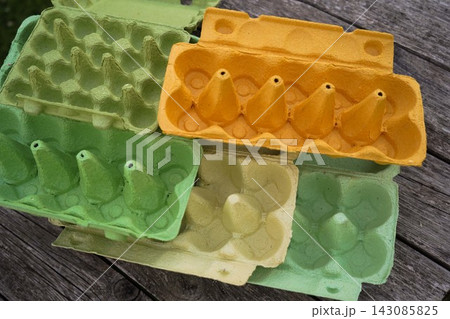 Empty protective pressed cardboard packaging for eggs on wooden texture backdrop Empty protective pressed cardboard packaging for eggs on wooden texture backdrop 143085825