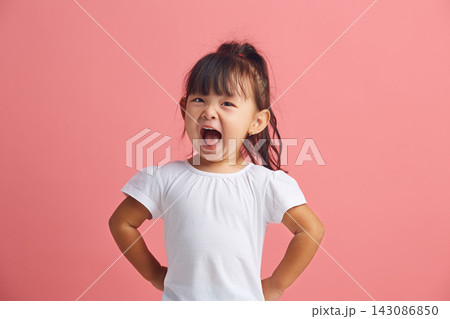 Cheerful little asian girl fun wide open mouth, has a happy expression wearing in white t shirt standing on a pink isolated background. Happy and joyful child in indoor, studio shot. Cheerful little asian girl fun wide open mouth, has a happy expression wearing in white t shirt standing on a pink isolated background. Happy and joyful child in indoor, studio shot. 143086850