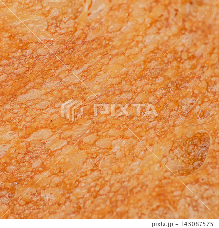 Close-up view of textured bread crust showcasing golden brown color and irregular surface patterns, highlighting the artisanal quality of freshly baked bread Close-up view of textured bread crust showcasing golden brown color and irregular surface patterns, highlighting the artisanal quality of freshly baked bread 143087575