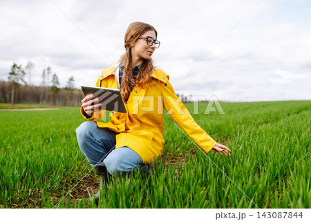 The woman agronomist uses a tablet, applications for monitoring the state of the field, plant The woman agronomist uses a tablet, applications for monitoring the state of the field, plant 143087844