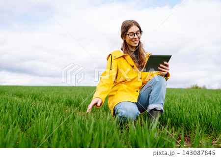 The woman agronomist uses a tablet, applications for monitoring the state of the field, plant The woman agronomist uses a tablet, applications for monitoring the state of the field, plant 143087845
