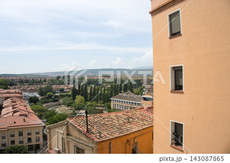 Ochre facade and tiled roofs framing a view over Tarazona towards the wind farm Ochre facade and tiled roofs framing a view over Tarazona towards the wind farm 143087865