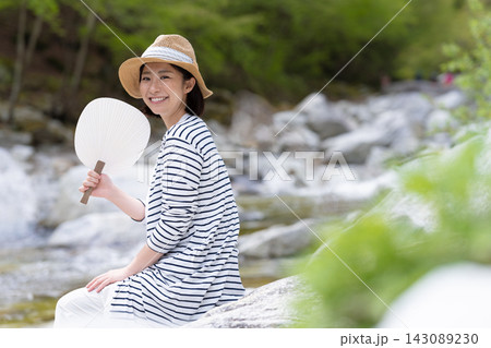 夏、川辺で団扇を持つ女性 夏、川辺で団扇を持つ女性 143089230
