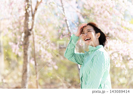 女性、春の桜、楽しそうな笑顔、手を上げる 女性、春の桜、楽しそうな笑顔、手を上げる 143089414