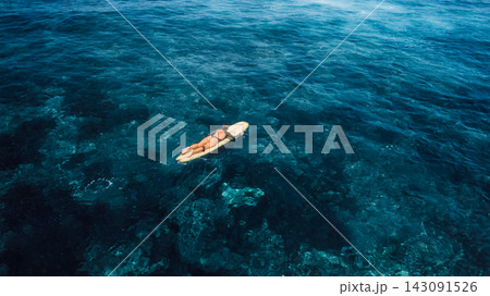Woman on surfboard in ocean. Drone view of woman during surfing 143091526