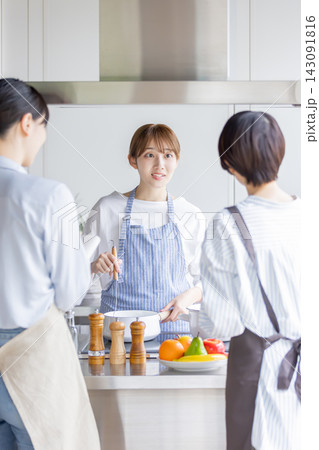 料理教室で調理を実演しながら説明する日本人女性 143091816