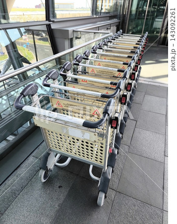 A row of luggage carts at an airport A row of luggage carts at an airport 143092261