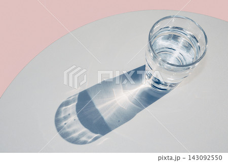 Glass of water casting strong shadows and natural caustic light patterns Glass of water casting strong shadows and natural caustic light patterns 143092550