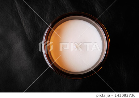 Unlit white wax candle in an amber glass jar, promoting cozy aromatherapy and relaxation Unlit white wax candle in an amber glass jar, promoting cozy aromatherapy and relaxation 143092736