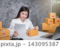 Successful entrepreneur business woman checking order via tablet with online sales and parcel shipping in her home office. 143095387