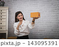 Successful entrepreneur business woman with online sales point to parcel package box present to her customers in home office. 143095391