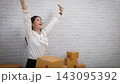 Happy Asian Business Woman Successful Excited Raised Hands Rejoicing. Asian small business owner is successful selling online using laptop computer. selling online, pacel box. 143095392